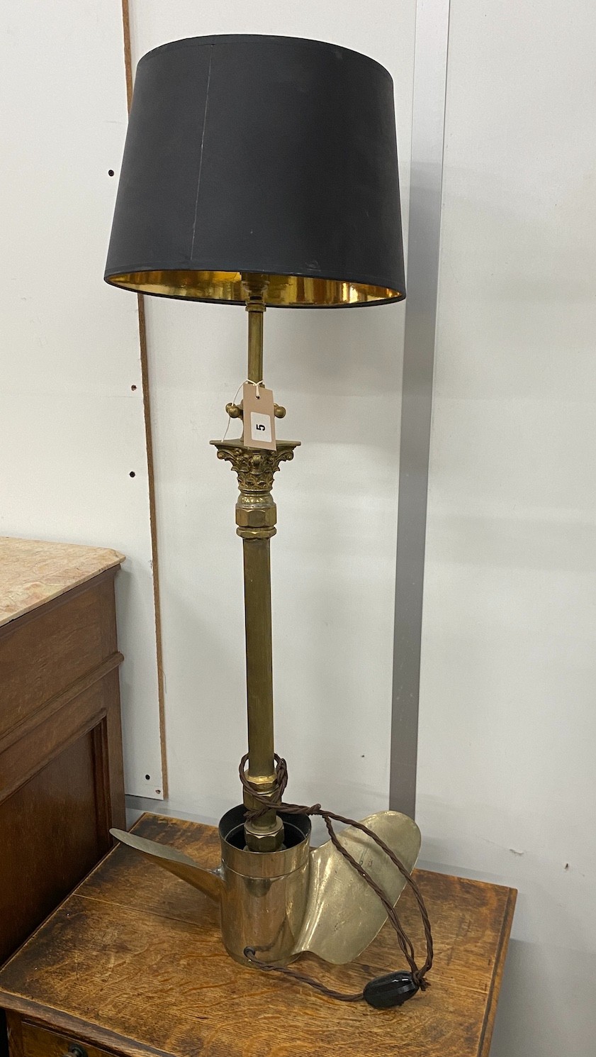 A brass Corinthian column standard lamp with ship propeller base, height including shade 92cm